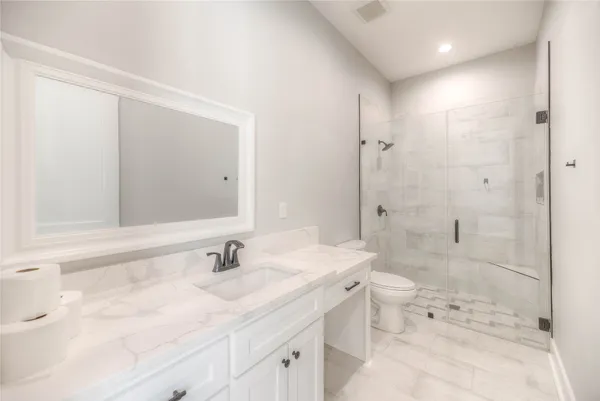 a bathroom with a sink toilet double vanity and shower