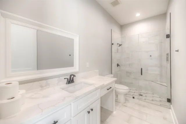 a bathroom with a sink toilet double vanity and shower