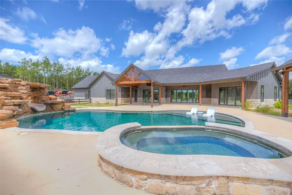 a view of house with swimming pool and sitting area