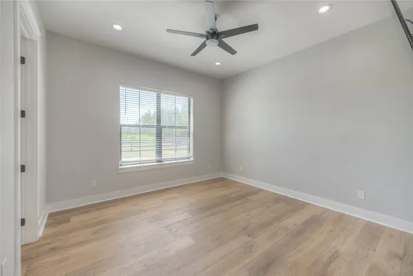 an empty room with a window and a ceiling fan