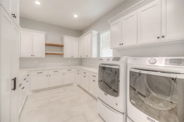 a utility room with cabinets washer and dryer