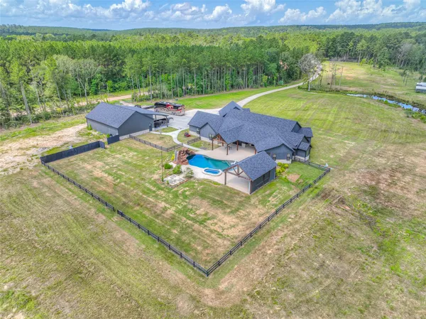 a view of a swimming pool with lawn chairs and plants
