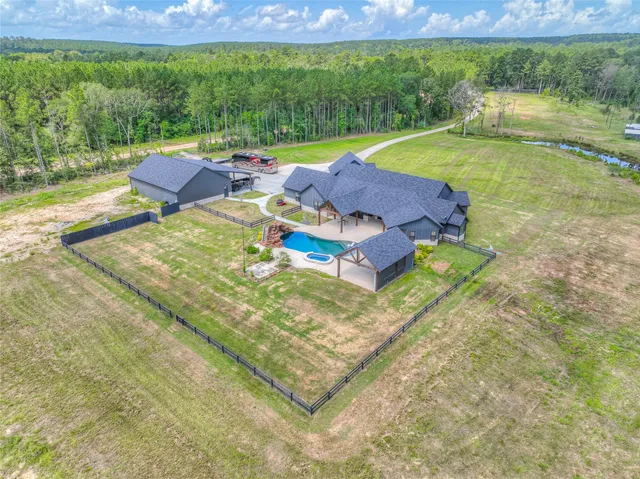 a view of a swimming pool with lawn chairs and plants