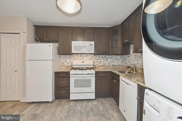 a kitchen with a white stove top oven and refrigerator