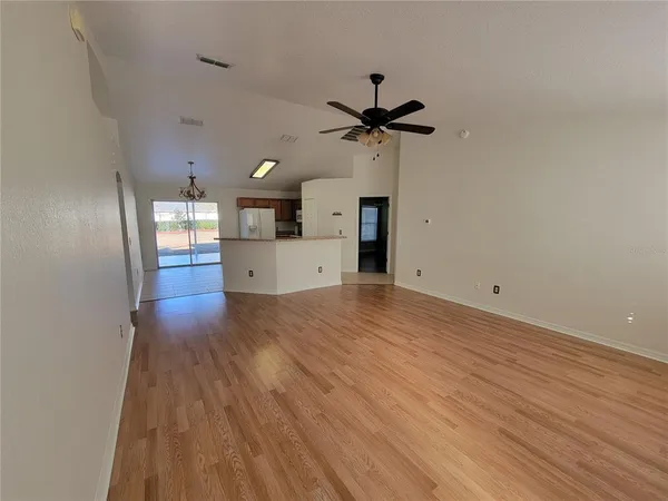 a view of a room with a wooden floor and ceiling fan