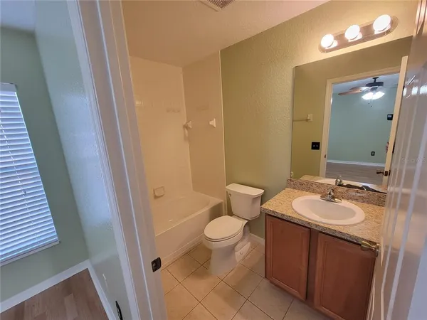 a bathroom with a sink a toilet a mirror and shower