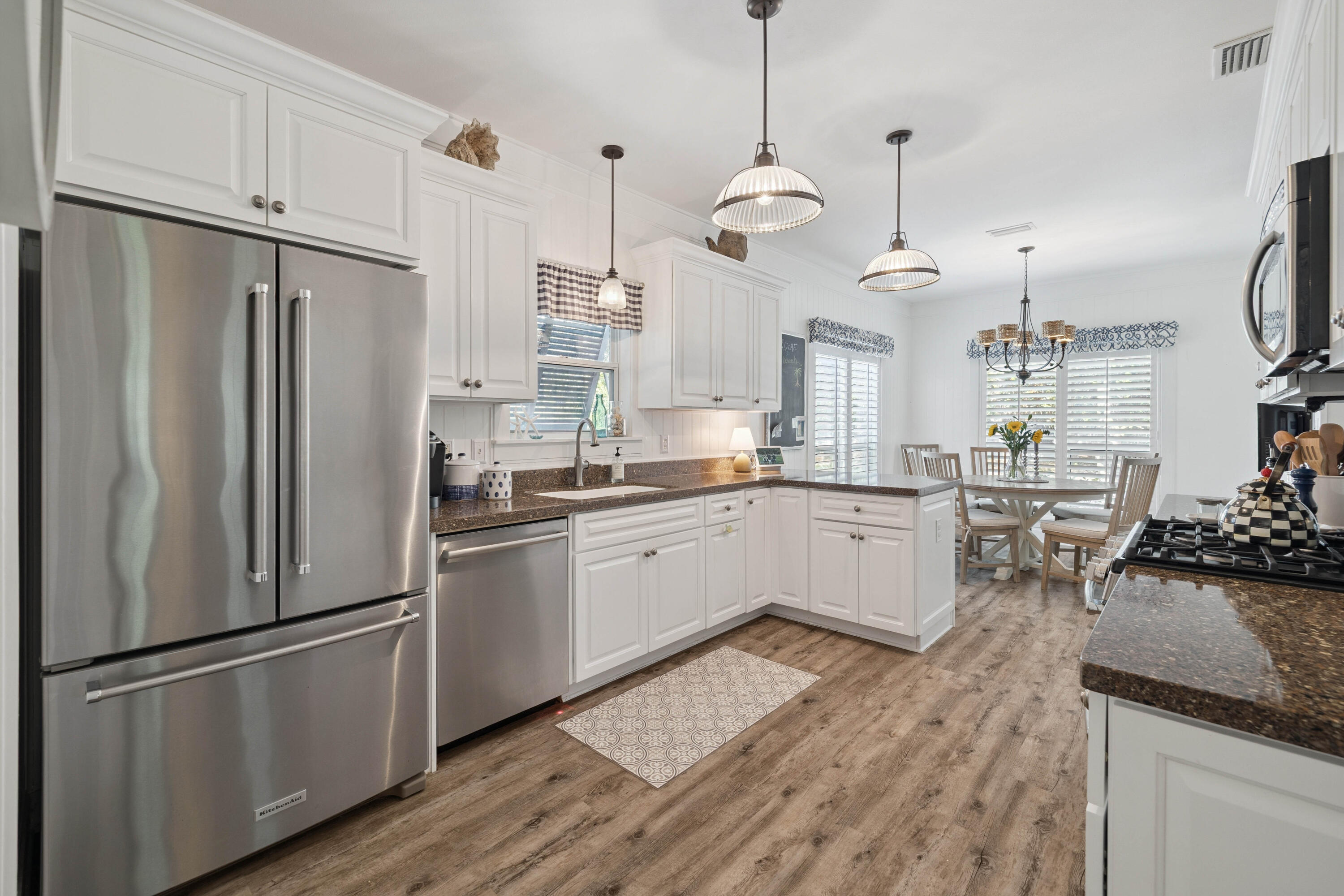 298 Cullman Avenue Santa Rosa Beach, FL 32459 - Photo 12 of 63 a kitchen with stainless steel appliances granite countertop a refrigerator a sink dishwasher a stove and white cabinets with wooden floor