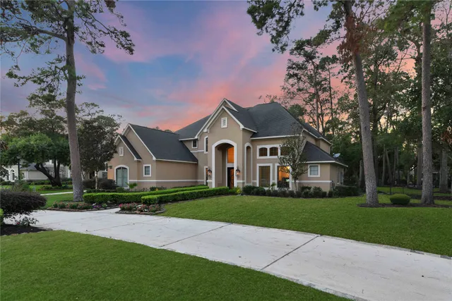 a view of a house with a yard and palm trees