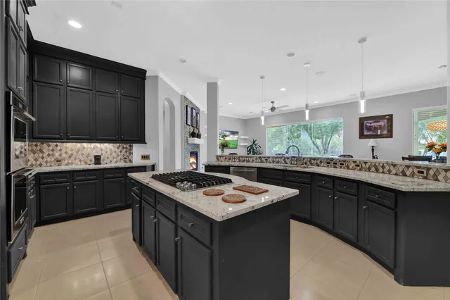 a kitchen with a stove sink and cabinets