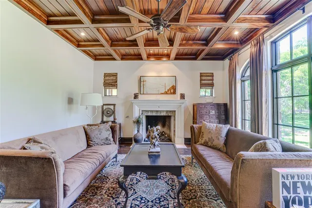 a living room with furniture a ceiling fan and a fireplace