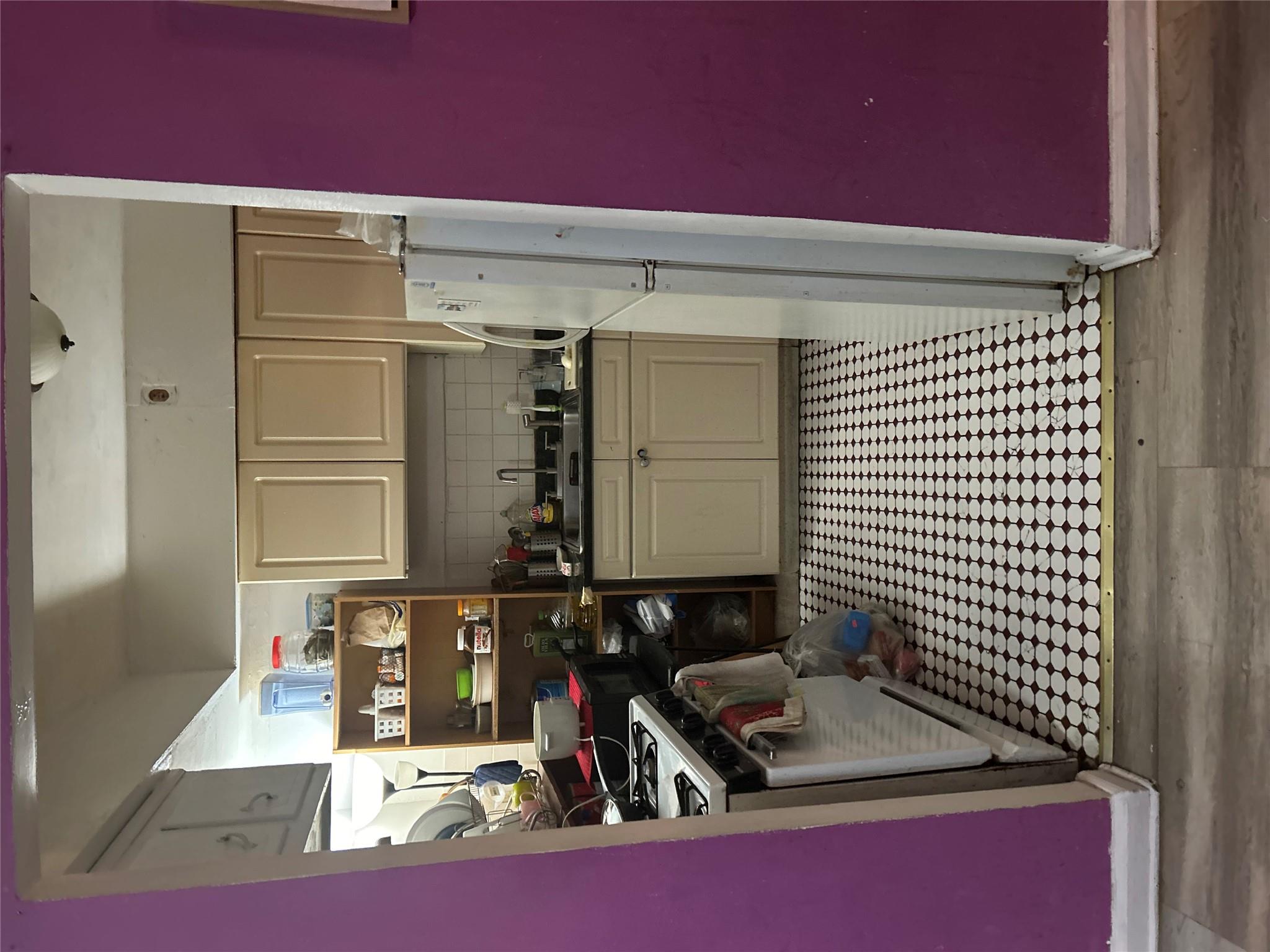 1210 White Plains Road Bronx, NY 10472 - Photo 1 of 5 Kitchen featuring sink, range, refrigerator, decorative backsplash, and cream cabinetry