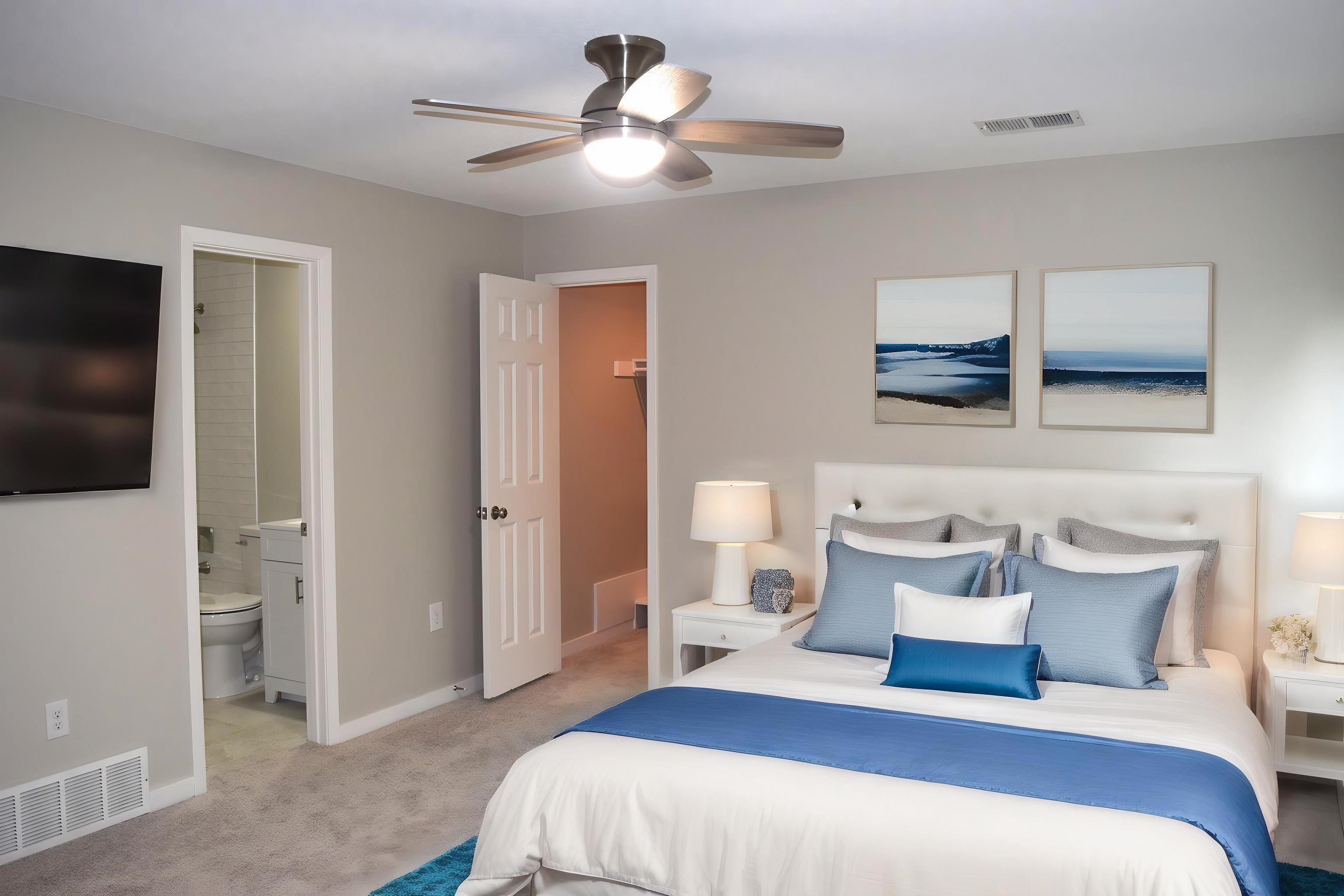 1831 Allenby Green, Unit 1831 Germantown, TN 38139 - Photo 16 of 25 a bedroom with a large bed a flat tv screen and a ceiling fan