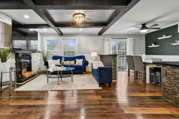 a living room with furniture a fireplace and a chandelier