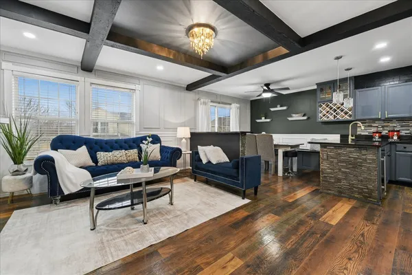 a kitchen with stainless steel appliances granite countertop a stove a sink dishwasher a dining table and chairs with wooden floor