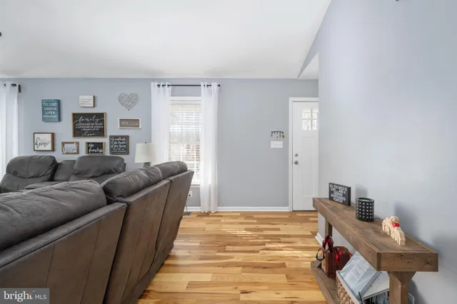 a view of a kitchen with kitchen island a stove a refrigerator cabinets and wooden floor