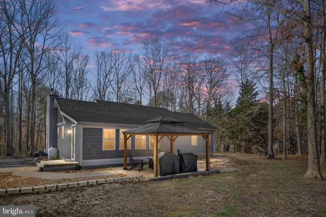 a view of a house with backyard and trees