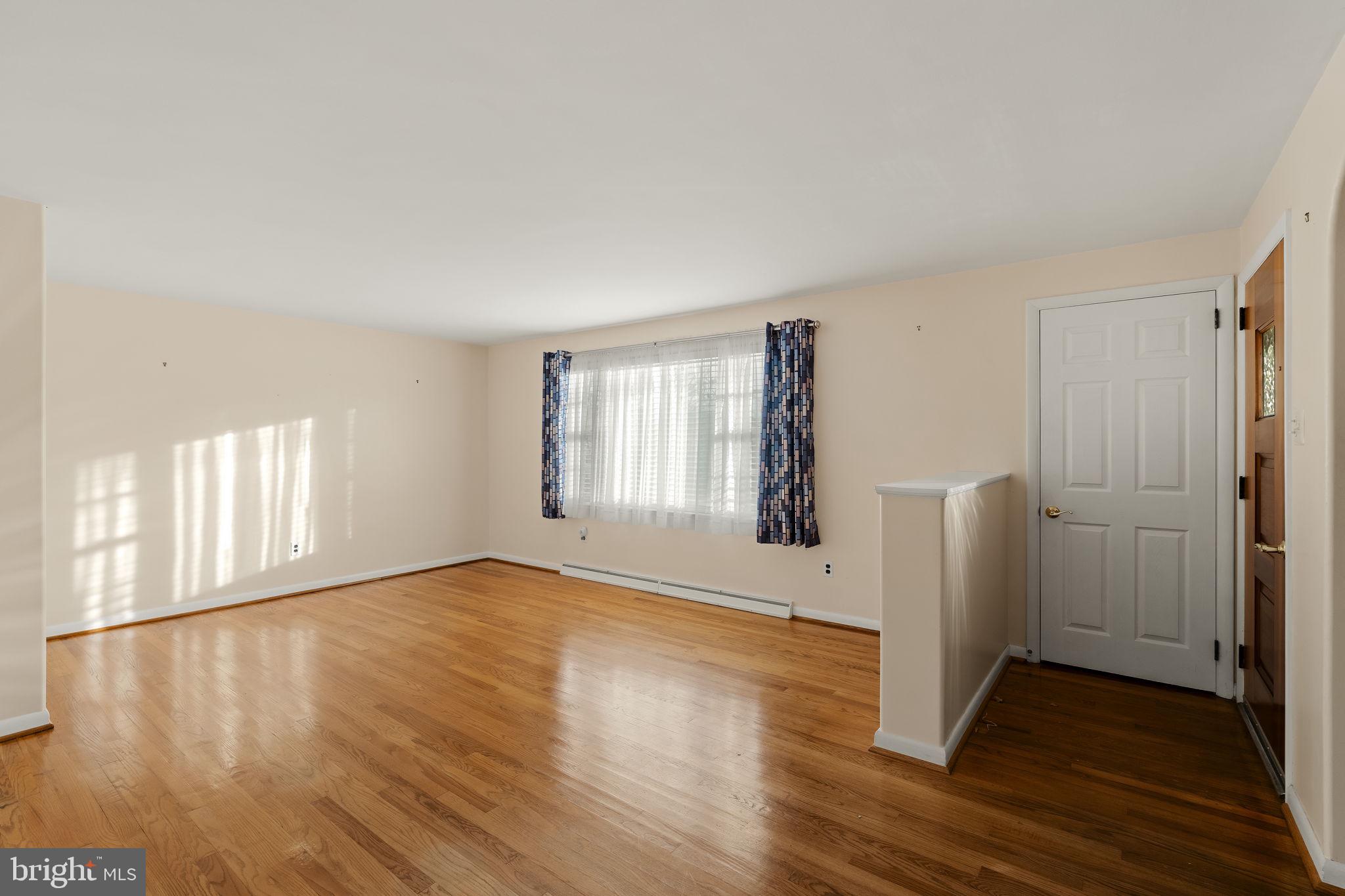 406 South Church Street Quarryville, PA 17566 - Photo 2 of 24 an empty room with wooden floor and windows