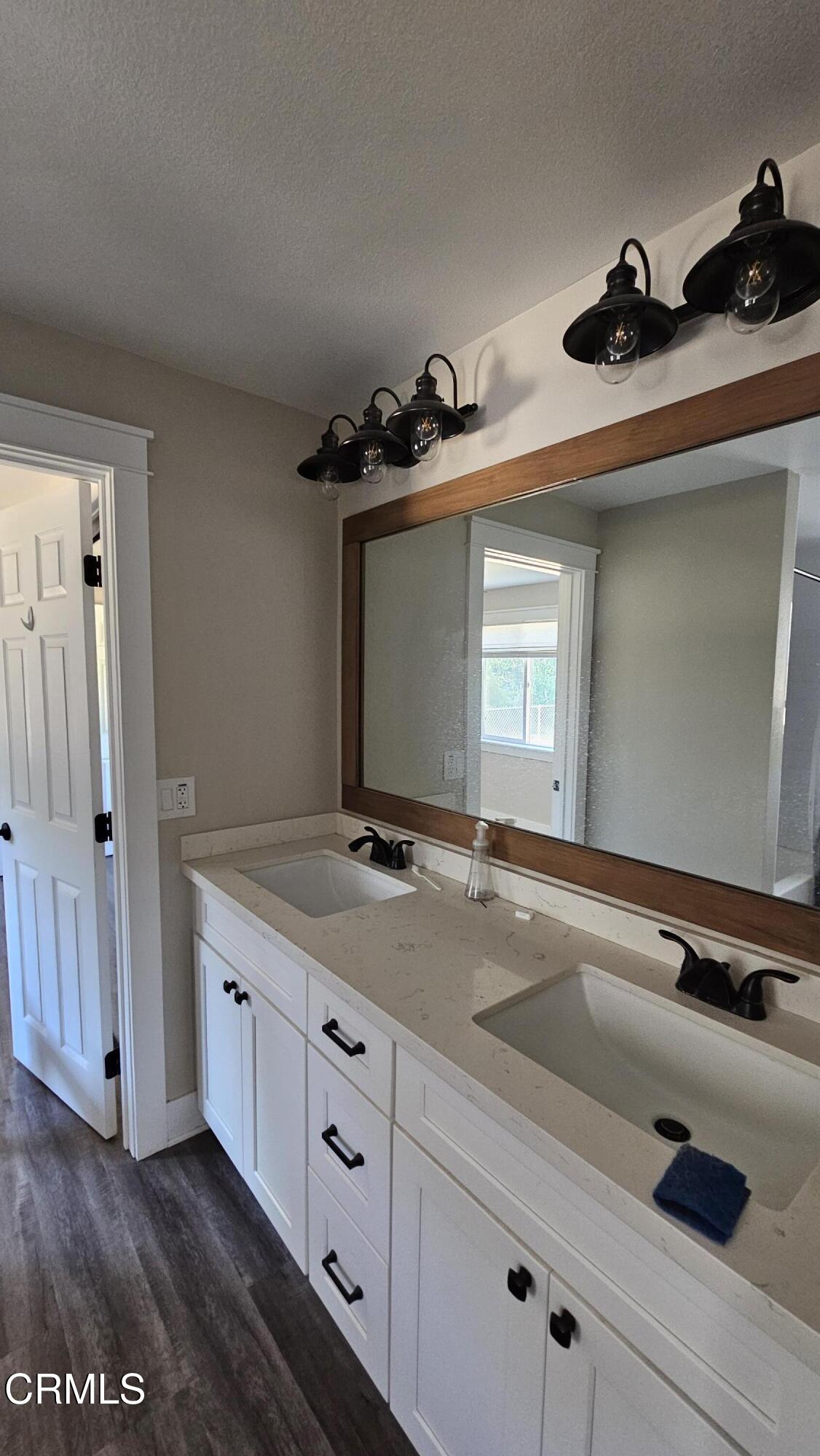 1032 West Newgrove Street Lancaster, CA 93534 - Photo 11 of 13 a bathroom with a sink and mirror