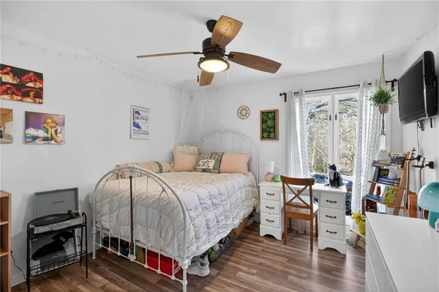 a spacious bedroom with a bed a flat screen tv and a large window