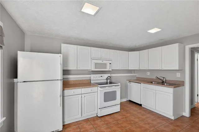 a kitchen with a sink a refrigerator a microwave and cabinets