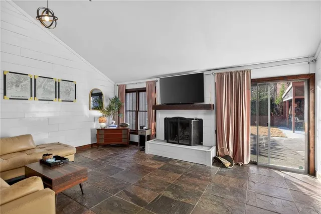 a living room with furniture a fireplace and a flat screen tv