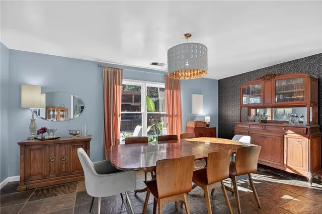 a dining room with furniture a chandelier and wooden floor