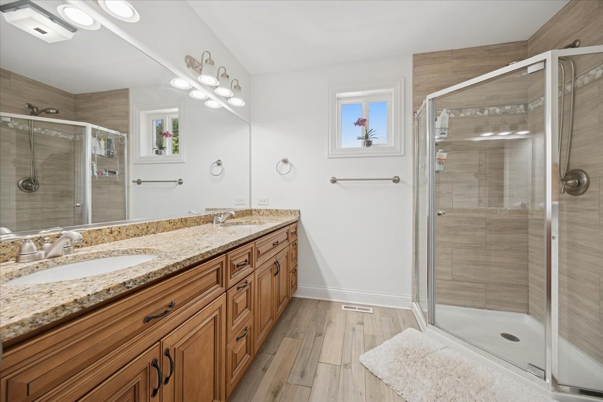 3931 Maple Avenue Brookfield, IL 60513 - Photo 16 of 24 a bathroom with a granite countertop sink a mirror and shower