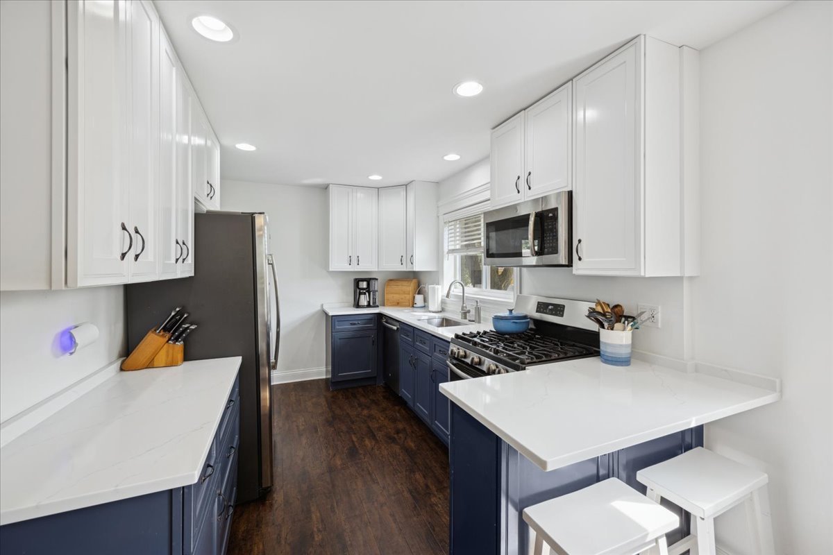 3931 Maple Avenue Brookfield, IL 60513 - Photo 7 of 24 a kitchen with a refrigerator a stove a sink and white cabinets with wooden floor