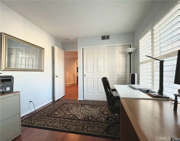 a view of a kitchen with kitchen island a sink wooden floor and a large window