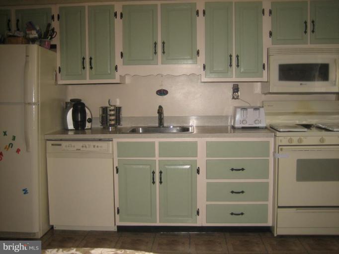 8352 Edgedale Road Parkville, MD 21234 - Photo 11 of 14 a kitchen with stainless steel appliances granite countertop a sink stove and cabinets