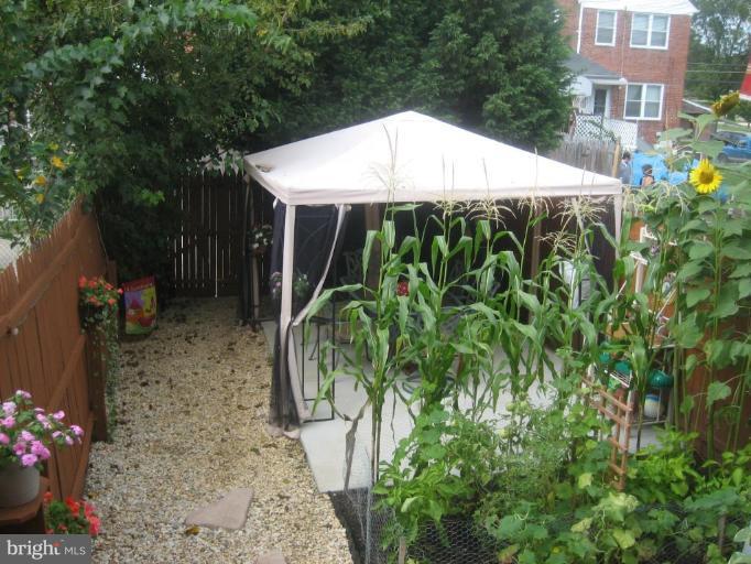 8352 Edgedale Road Parkville, MD 21234 - Photo 8 of 14 a backyard of a house with table and chairs under an umbrella