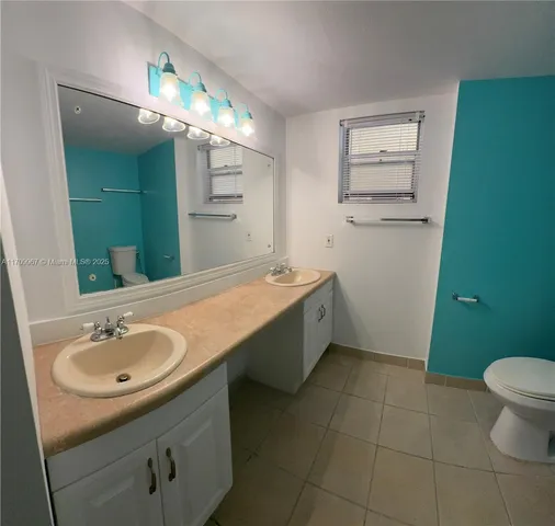 a bathroom with a sink a toilet and mirror