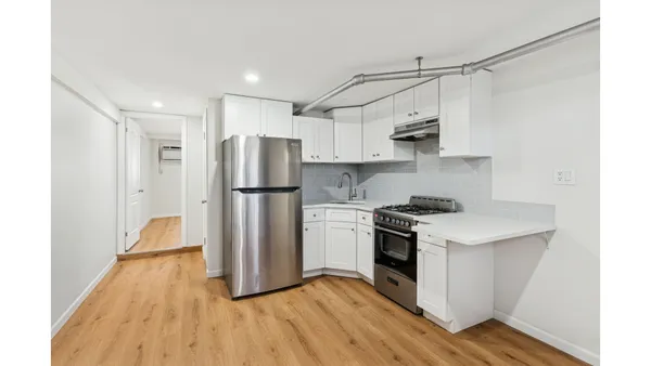 a kitchen with a refrigerator a sink and wooden floor