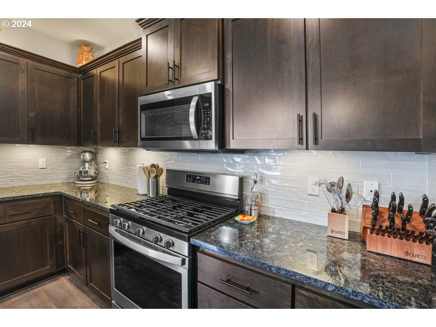 59551 Emerald Loop St. Helens, OR 97051 - Photo 23 of 40 a kitchen with stainless steel appliances granite countertop a sink stove and microwave