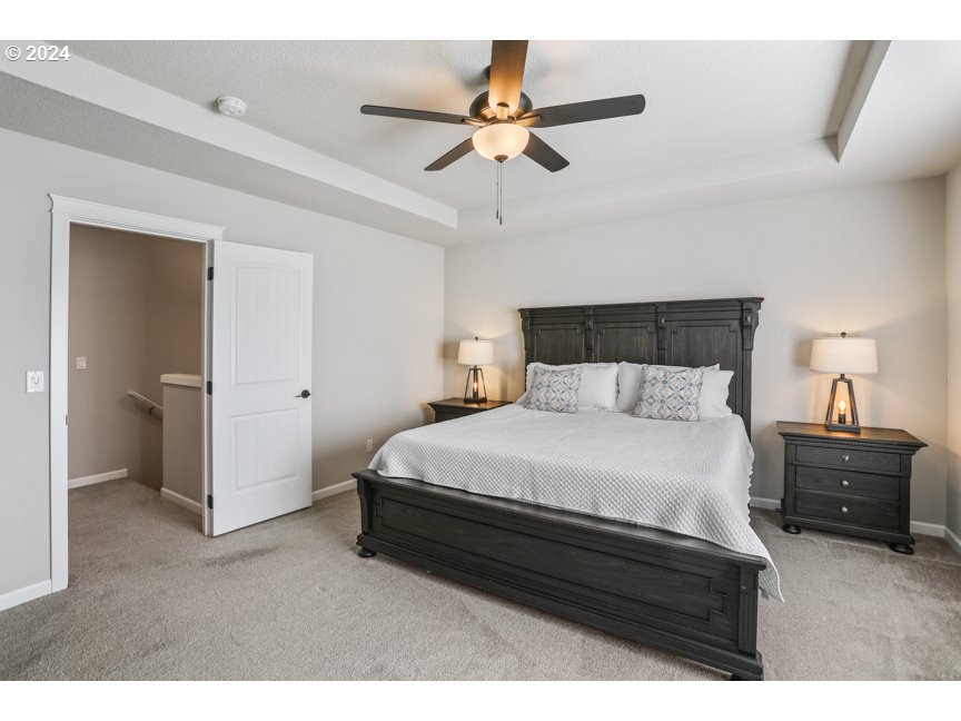 59551 Emerald Loop St. Helens, OR 97051 - Photo 29 of 40 a bedroom with a bed and a ceiling fan