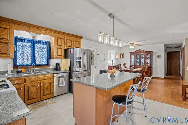 a kitchen with stainless steel appliances granite countertop a sink a stove and a refrigerator