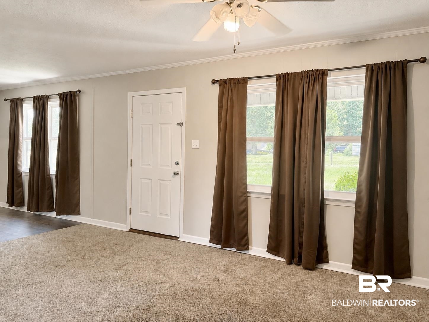 11115 Appleton Road Castleberry, AL 36432 - Photo 5 of 18 Living area featuring light beige carpeting and white baseboards