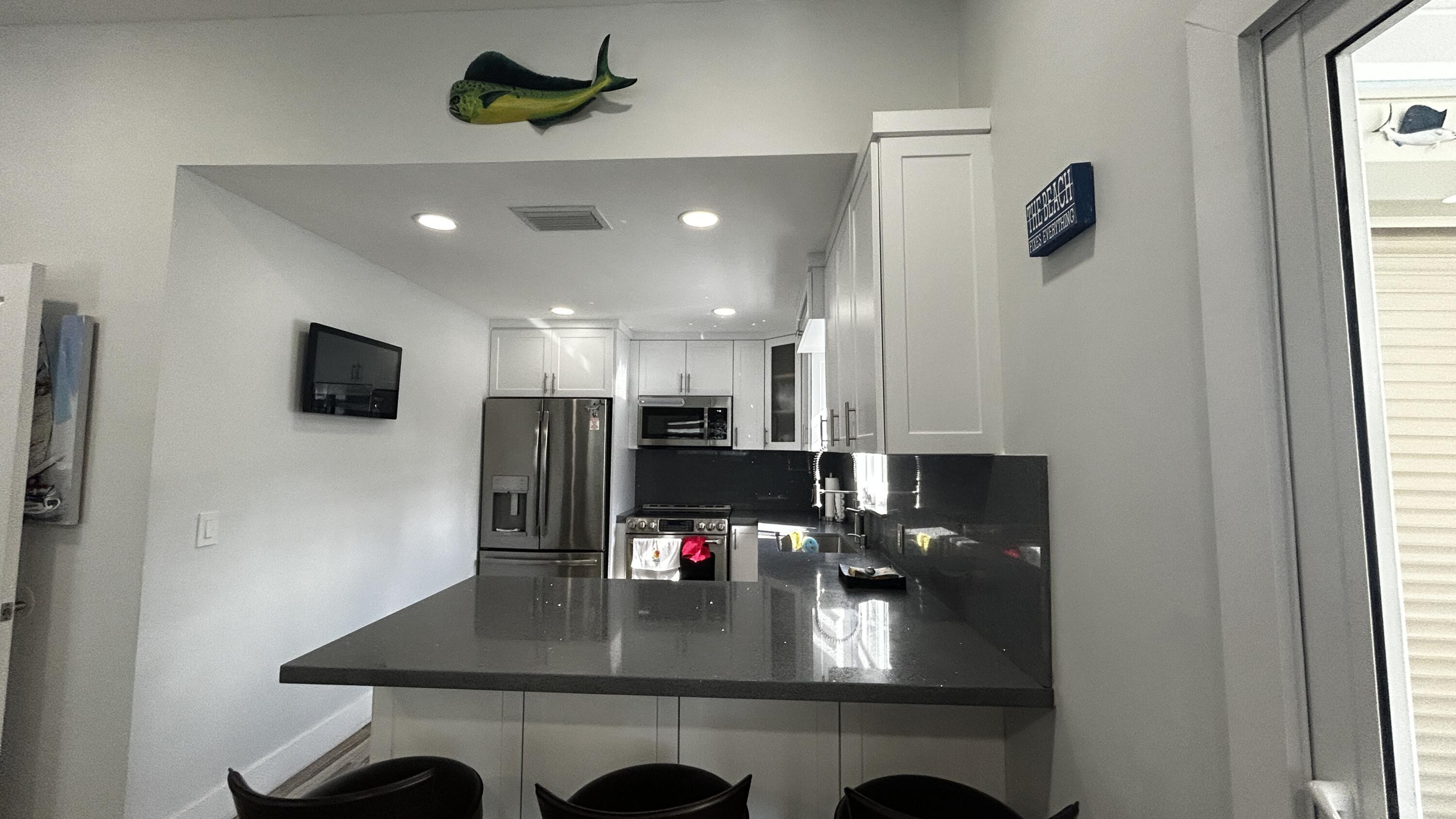 423 Mahogany Avenue Key Largo, FL 33037 - Photo 11 of 37 a view of kitchen and living room with a flat screen tv