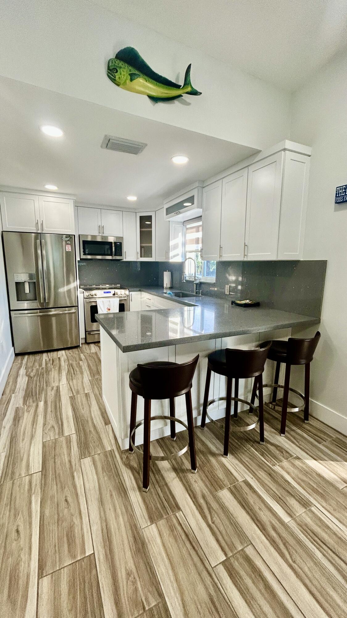 423 Mahogany Avenue Key Largo, FL 33037 - Photo 23 of 37 a kitchen with stainless steel appliances kitchen island granite countertop a table chairs sink and cabinets