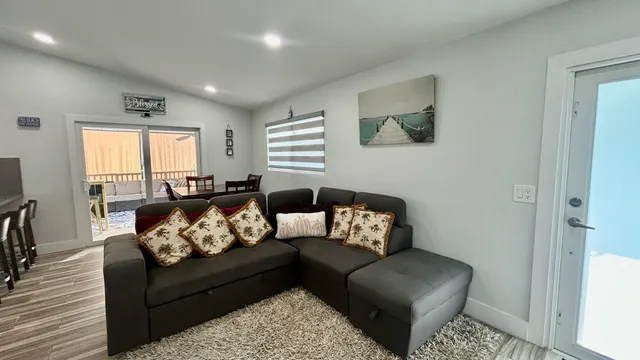 a balcony of a house with wooden floor outdoor seating and yard in the back