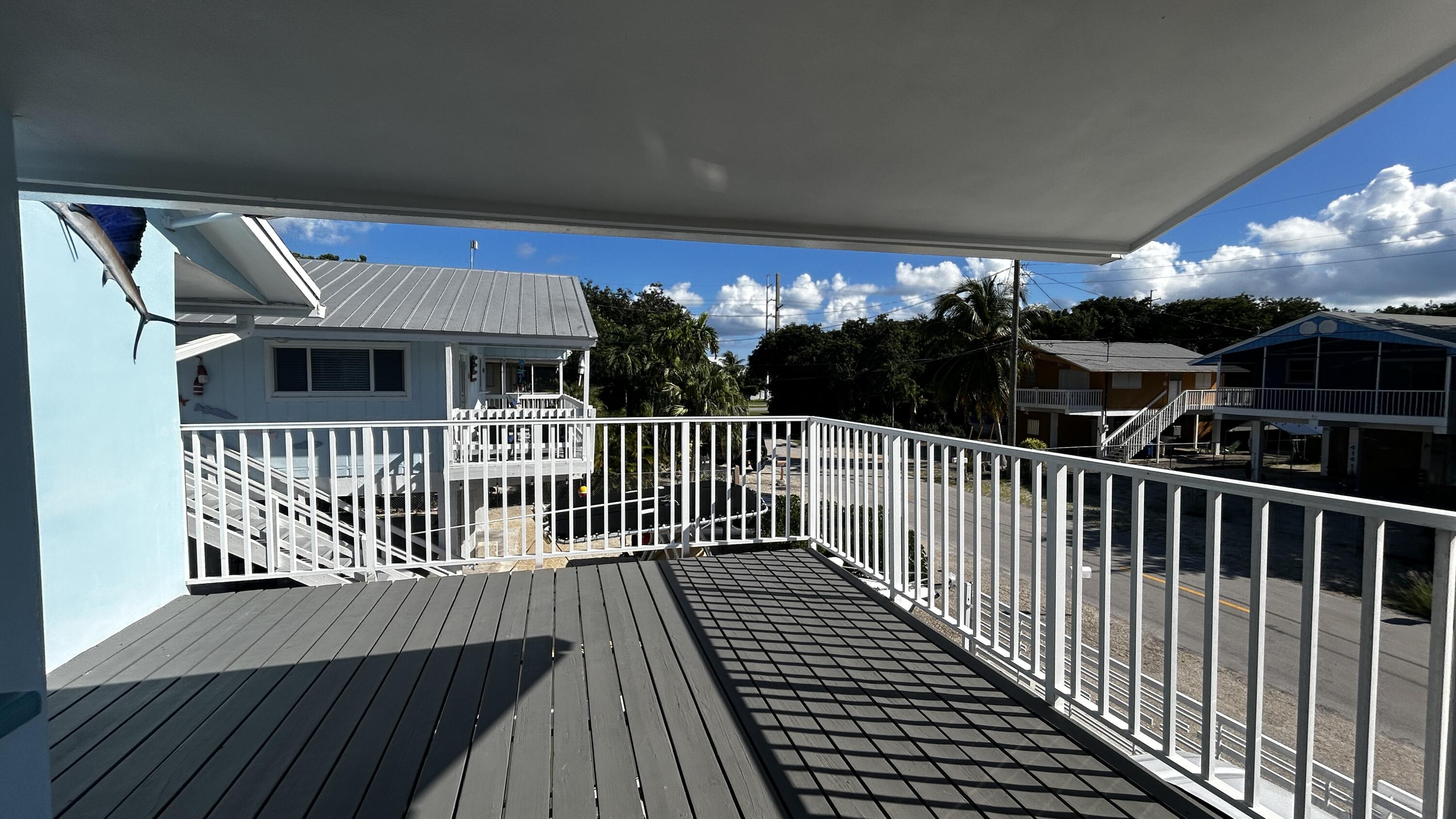 423 Mahogany Avenue Key Largo, FL 33037 - Photo 36 of 37 a balcony of a house with wooden floor outdoor seating and yard in the back