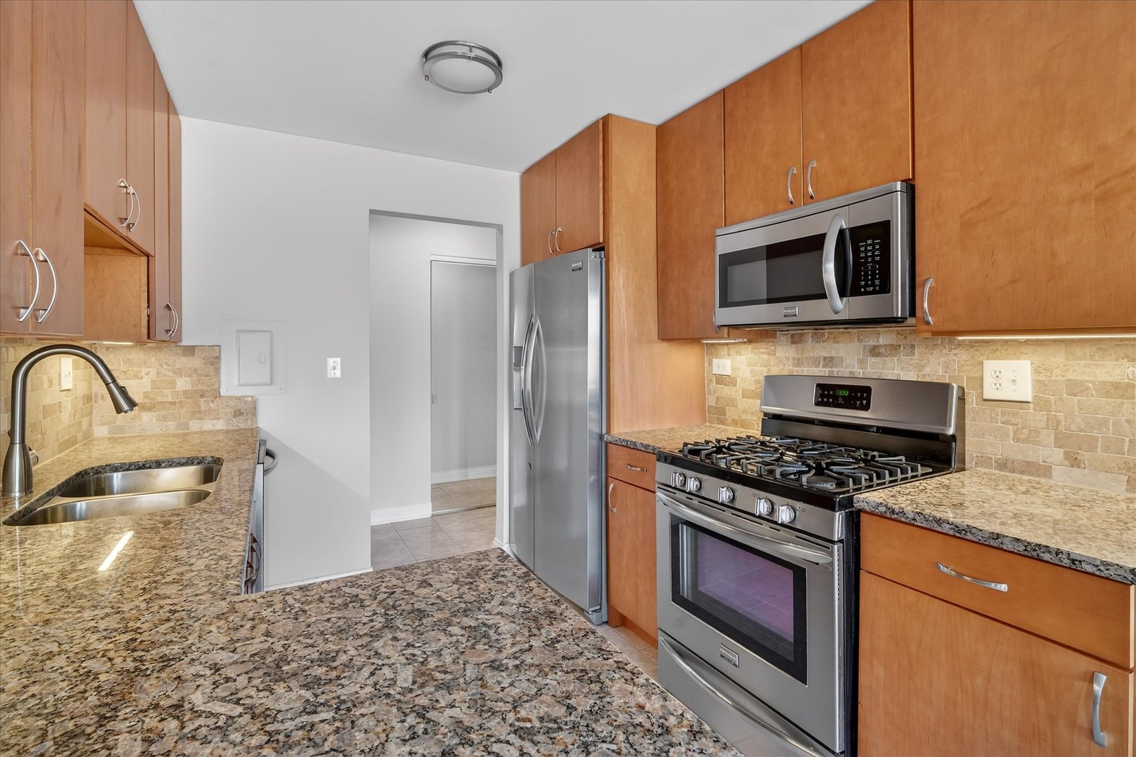 940 East Old Willow Road, Unit 312 Prospect Heights, IL 60070 - Photo 13 of 28 a kitchen with stainless steel appliances granite countertop a stove microwave and refrigerator