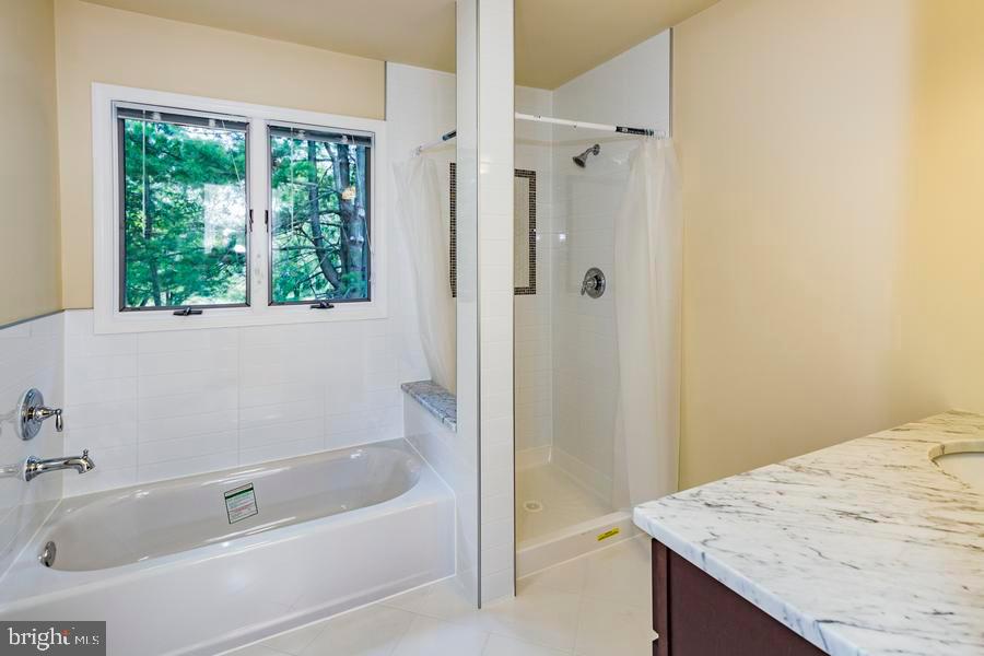20 Exeter Court Princeton, NJ 08540 - Photo 15 of 25 a bathroom with a granite countertop bathtub a sink and a shower