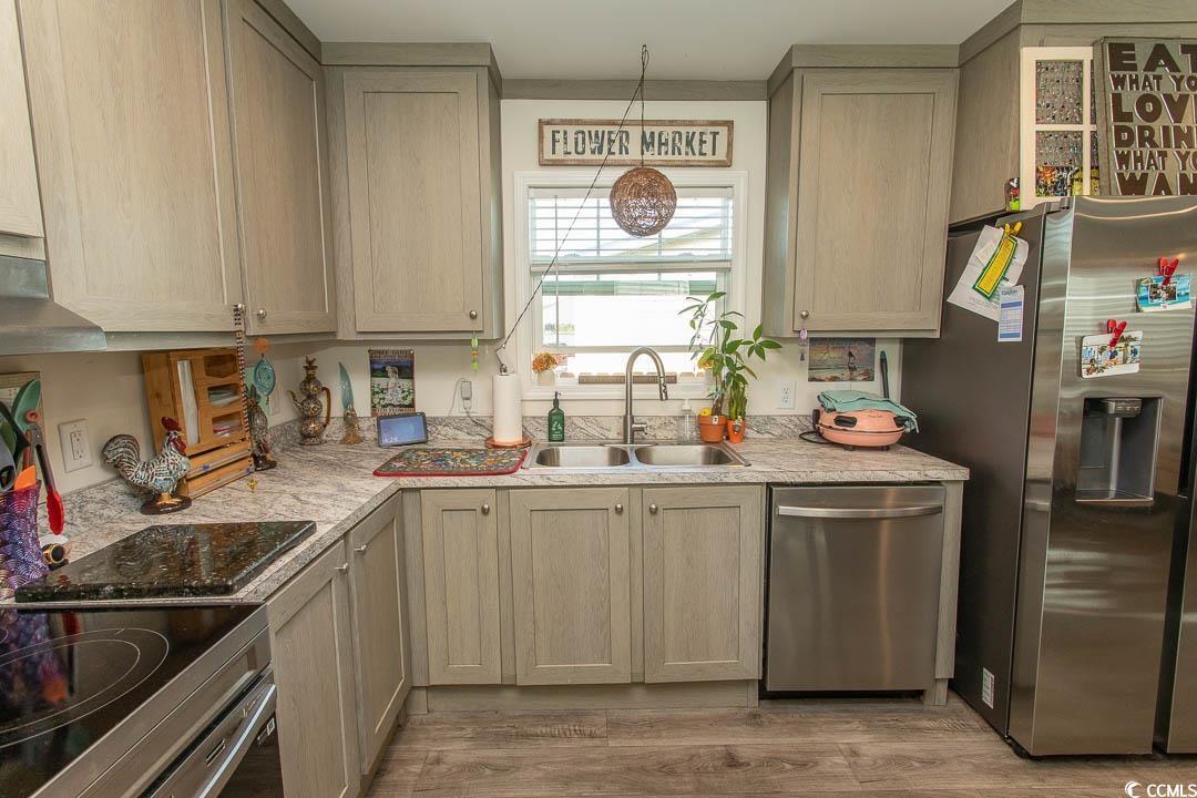 2737 Capricorn Drive Myrtle Beach, SC 29575 - Photo 13 of 27 Kitchen with appliances with stainless steel finishes, light wood-style flooring, under cabinet range hood, and light brown cabinets