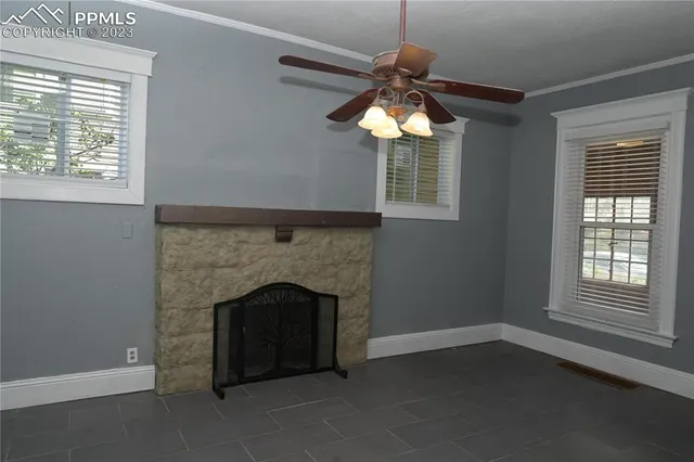 a living room with a fireplace and windows