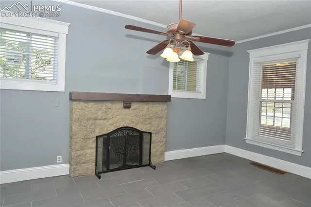 an empty room with windows and fireplace