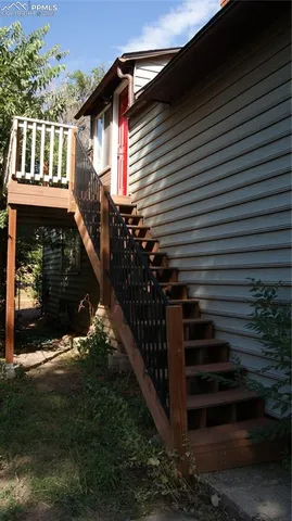 a view of a house with a yard and stairs