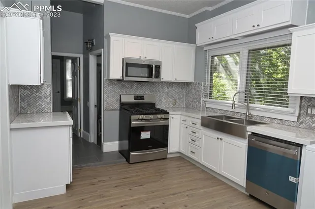 a kitchen with stainless steel appliances granite countertop a stove a sink and a microwave