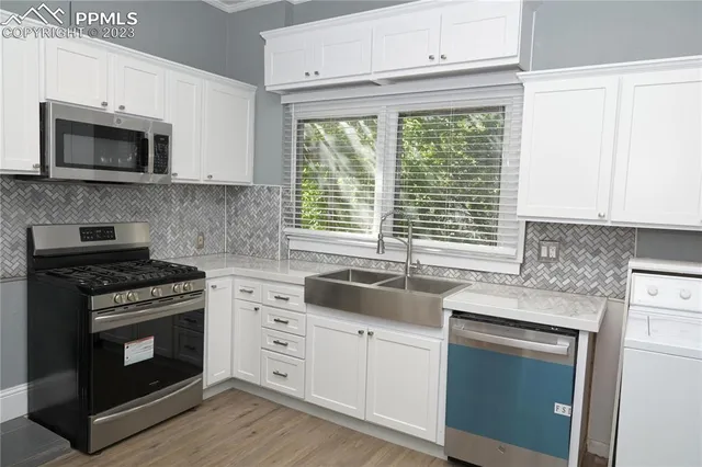 a kitchen with granite countertop white cabinets and appliances