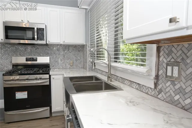 a kitchen with granite countertop a stove and a microwave